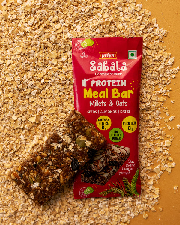 Millets & Oats Meal Bar with seeds, almonds, and dates on oat flakes background, high protein and fiber snack