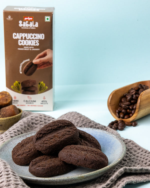 Millet Cappuccino Cookies on a plate with coffee beans and product packaging in the background